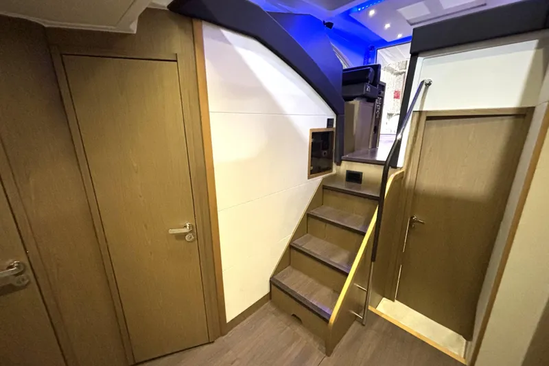  Yacht Photos Pics Interior of 2015 Beneteau Gran Turismo 49 yacht, featuring wooden stairs and doors.