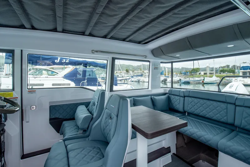 Egret Yacht Photos Pics Luxurious interior of 2023 Axopar 37 boat with blue seating and marina view.