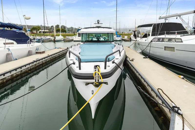 Egret Yacht Photos Pics 2023 Axopar 37 boat docked in marina, surrounded by other vessels.