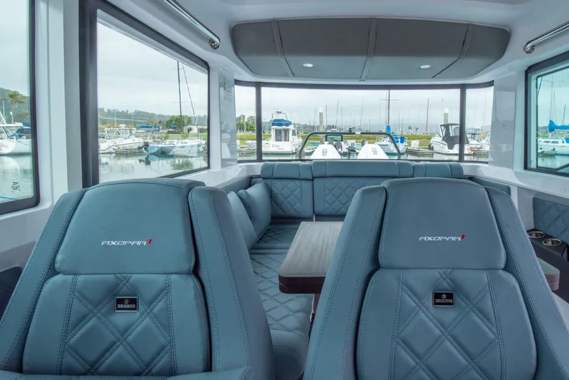 Egret Yacht Photos Pics Interior of 2023 Axopar 37 boat with luxurious seating and marina view.