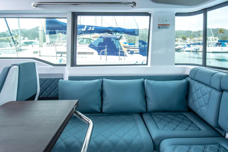 Egret Yacht Photos Pics Luxurious interior of 2023 Axopar 37 boat with blue seating and marina view.