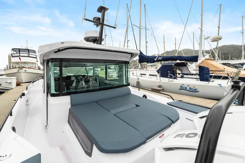 Egret Yacht Photos Pics 2023 Axopar 37 boat docked at marina with sailboats in background.