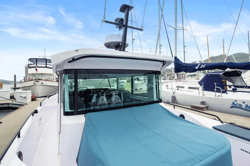 Egret Yacht Photos Pics 2023 Axopar 37 boat docked at marina, featuring sleek design and blue cover.