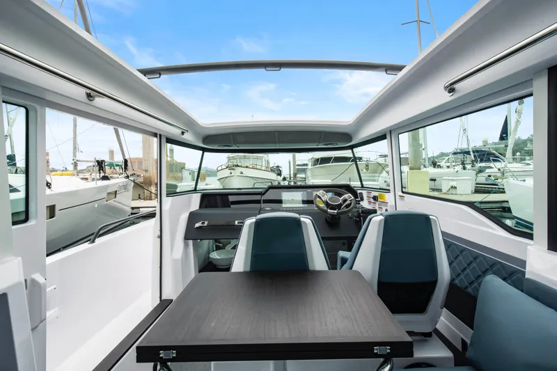 Egret Yacht Photos Pics 2023 Axopar 37 boat interior with modern seating and steering, docked at marina.