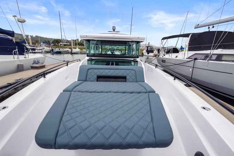 Egret Yacht Photos Pics 2023 Axopar 37 boat with luxurious seating, docked in a marina.