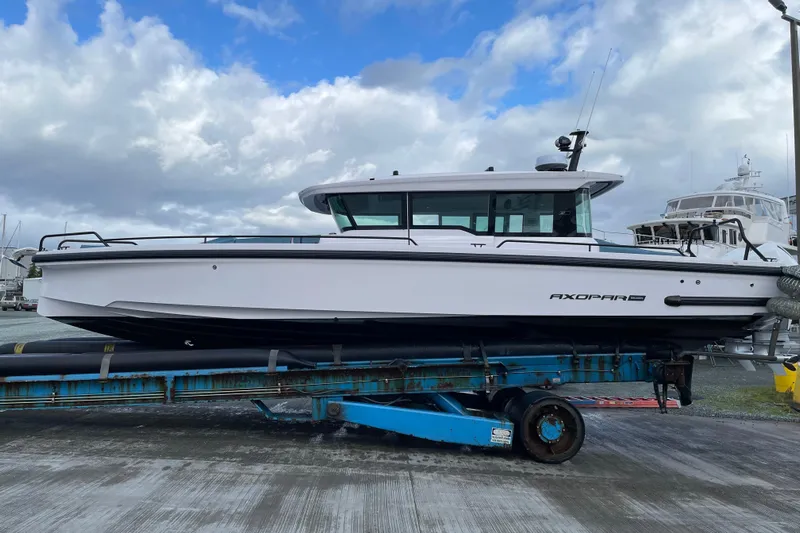 Egret Yacht Photos Pics 2023 Axopar 37 boat on trailer under cloudy sky at marina.