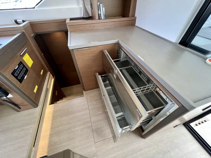 Echo Yacht Photos Pics Modern kitchen area in 2023 Lagoon 50 yacht with open drawers and sleek design.