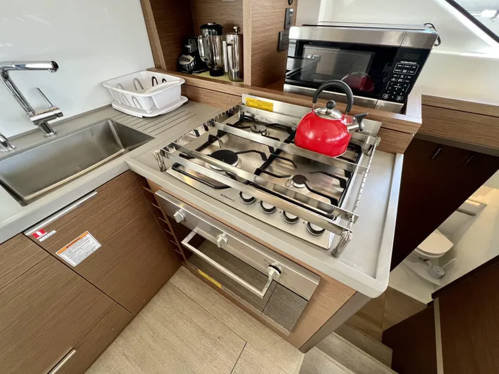 Echo Yacht Photos Pics Modern kitchen in 2023 Lagoon 50 yacht with stove, sink, and microwave.