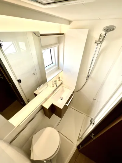 Echo Yacht Photos Pics Modern bathroom in 2023 Lagoon 50 yacht with shower, sink, and toilet.