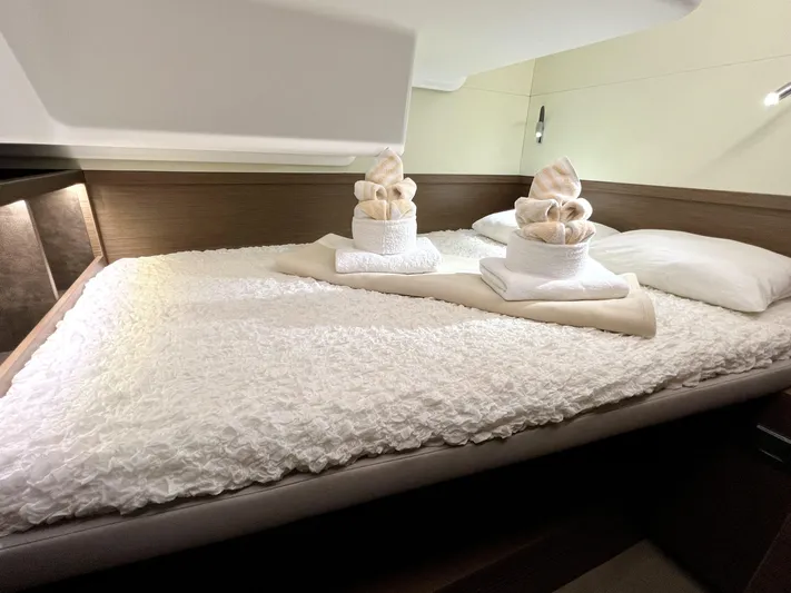 Echo Yacht Photos Pics Luxurious cabin interior of 2023 Lagoon 50 yacht with neatly arranged towels on bed.