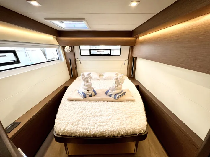 Echo Yacht Photos Pics Luxurious cabin interior of 2023 Lagoon 50 yacht with cozy bed and elegant decor.