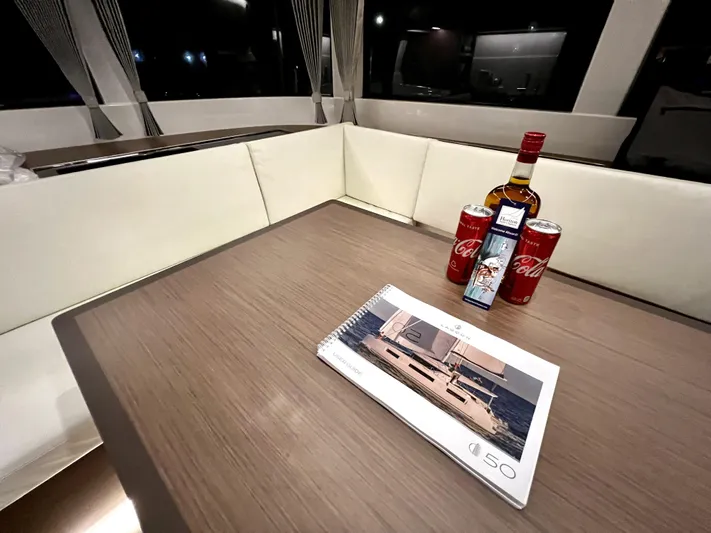 Echo Yacht Photos Pics 2023 Lagoon 50 yacht interior with brochure, drinks on table.
