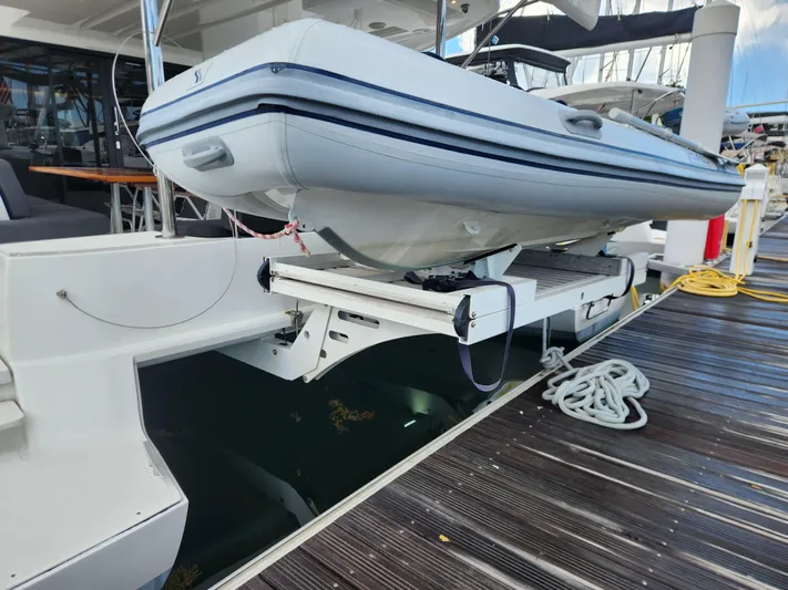 Echo Yacht Photos Pics 2023 Lagoon 50 yacht with a tender on davits at the dock.