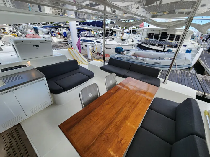 Echo Yacht Photos Pics 2023 Lagoon 50 yacht with sleek seating and wooden table in marina setting.