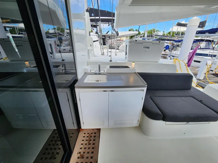 Echo Yacht Photos Pics 2023 Lagoon 50 yacht with outdoor sink and seating area in marina.