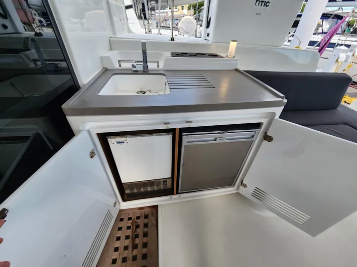 Echo Yacht Photos Pics Outdoor kitchenette on 2023 Lagoon 50 yacht with sink, fridge, and storage.