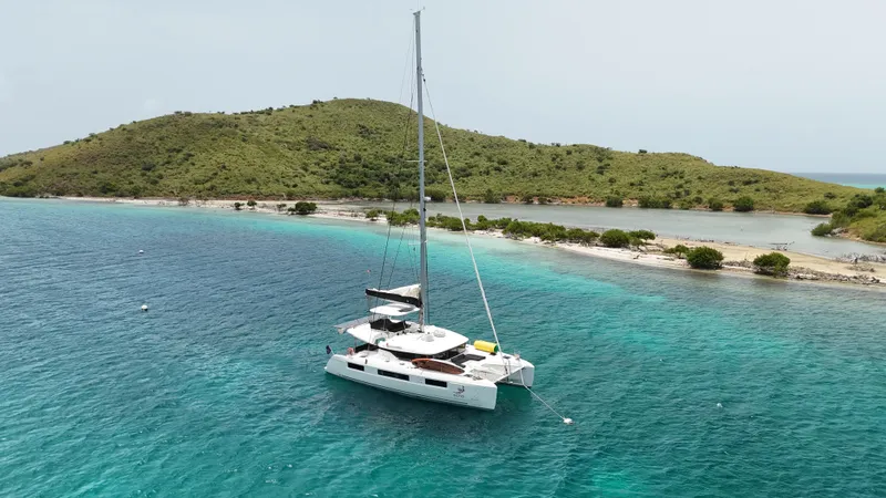 Echo Yacht Photos Pics 2023 Lagoon 50 catamaran sailing near a tropical island with clear turquoise waters.