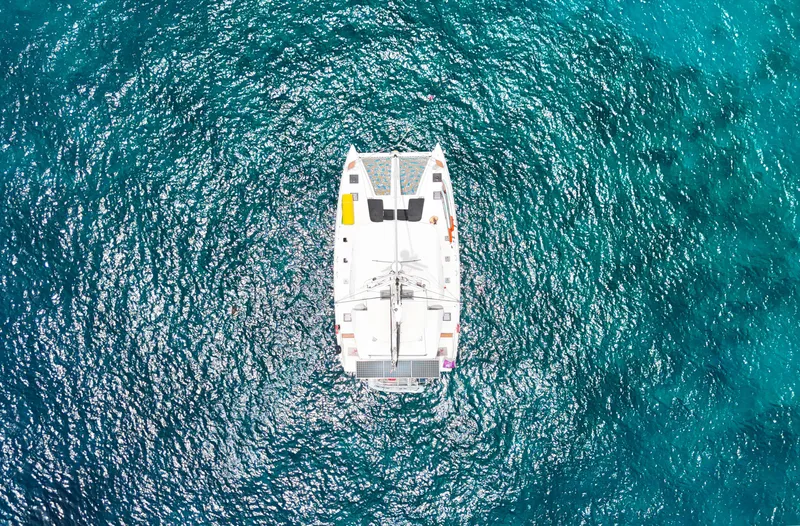 Echo Yacht Photos Pics Aerial view of 2023 Lagoon 50 catamaran on vibrant blue ocean waters.