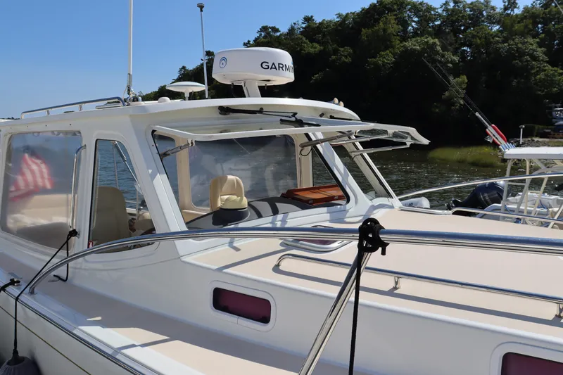 Rambler VIII Yacht Photos Pics 2013 MJM 36z Downeast boat with Garmin radar, docked near lush greenery.