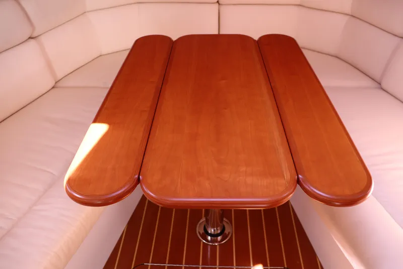 Rambler VIII Yacht Photos Pics Wooden table in 2013 MJM 36z Downeast boat interior with cushioned seating.