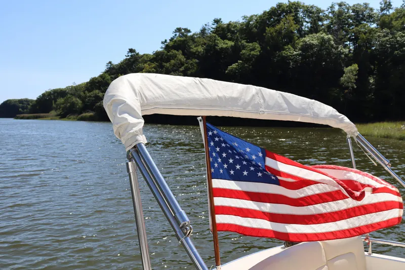 Rambler VIII Yacht Photos Pics MJM 36z Downeast 2013 boat with American flag on a serene lake.