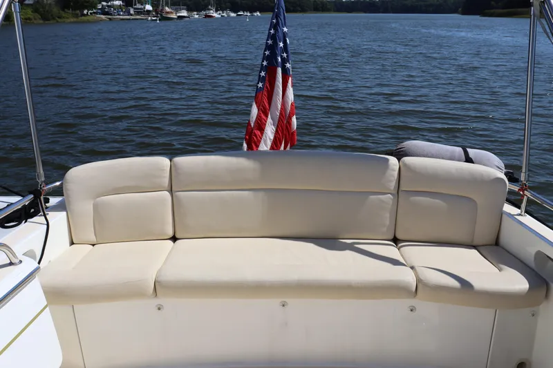 Rambler VIII Yacht Photos Pics 2013 MJM 36z Downeast boat with beige seating and American flag on a calm lake.