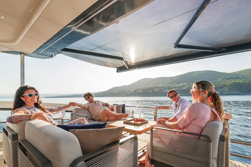  Yacht Photos Pics People relaxing on the 2026 Absolute Navetta 62 yacht, enjoying a scenic ocean view.