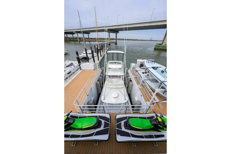 Compass Rose Yacht Photos Pics 2011 C & G Boatworks Explorer docked with jet skis, under a bridge.