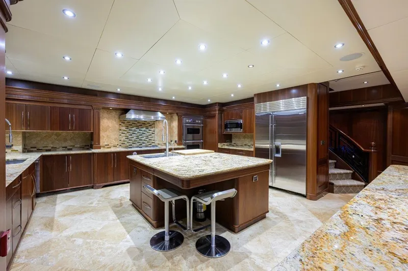 Compass Rose Yacht Photos Pics Luxurious yacht kitchen with granite countertops, stainless steel appliances, and elegant wood cabinetry.