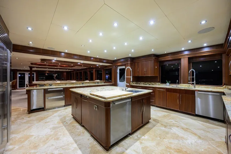 Compass Rose Yacht Photos Pics Luxurious yacht kitchen interior with wooden cabinetry, marble countertops, and modern lighting, C & G Boatworks Explorer 2011.
