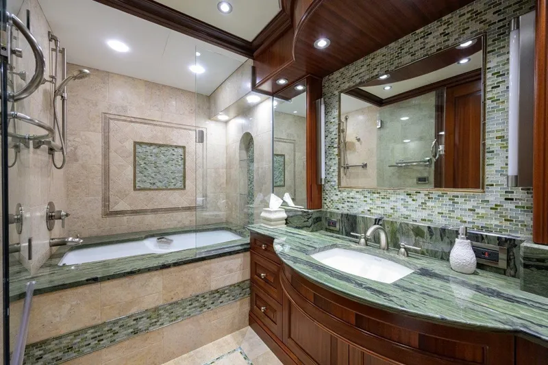 Compass Rose Yacht Photos Pics Luxurious yacht bathroom with green marble, glass shower, and elegant wood cabinetry, C & G Boatworks Explorer 2011.