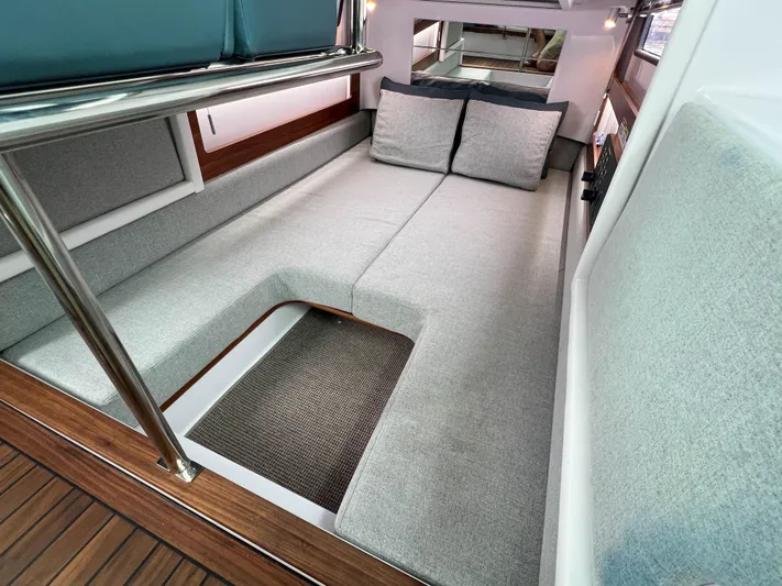 Girafft Yacht Photos Pics 2022 Axopar 28 Cabin Aft Cabin interior with gray cushions and wooden flooring.