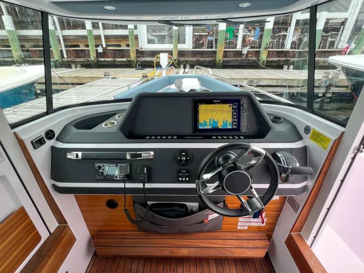 Girafft Yacht Photos Pics 2022 Axopar 28 Cabin Aft Cabin helm with navigation display and steering wheel.