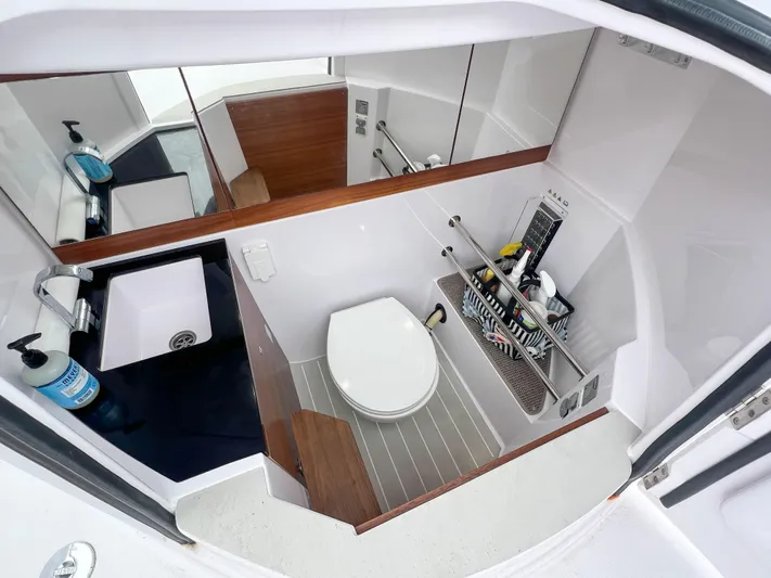 Girafft Yacht Photos Pics 2022 Axopar 28 Cabin Aft Cabin bathroom with toilet, sink, and storage shelves.
