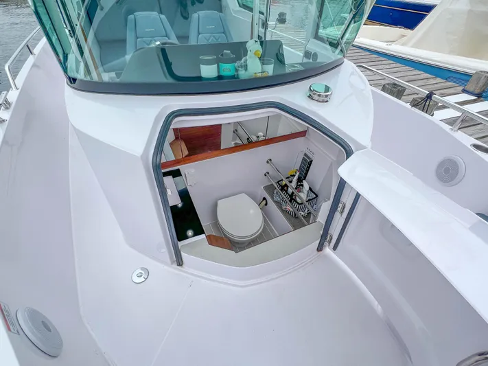 Girafft Yacht Photos Pics 2022 Axopar 28 Cabin Aft Cabin boat with open hatch revealing interior toilet.