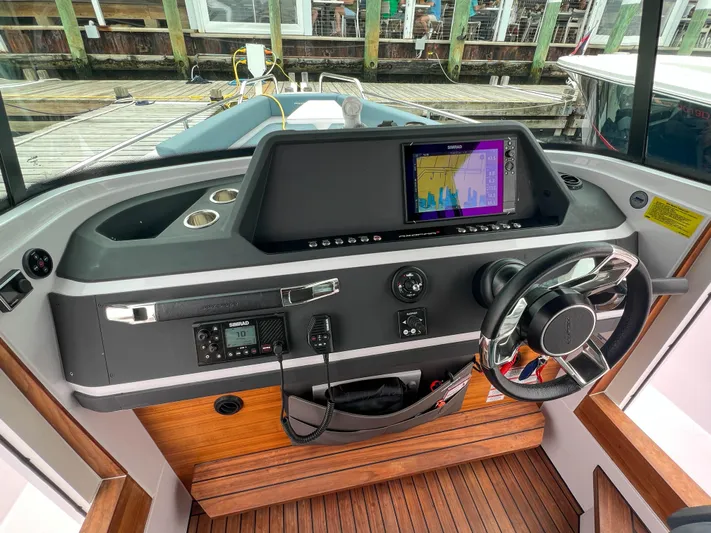 Girafft Yacht Photos Pics 2022 Axopar 28 Cabin Aft Cabin helm with modern navigation system and sleek steering wheel.