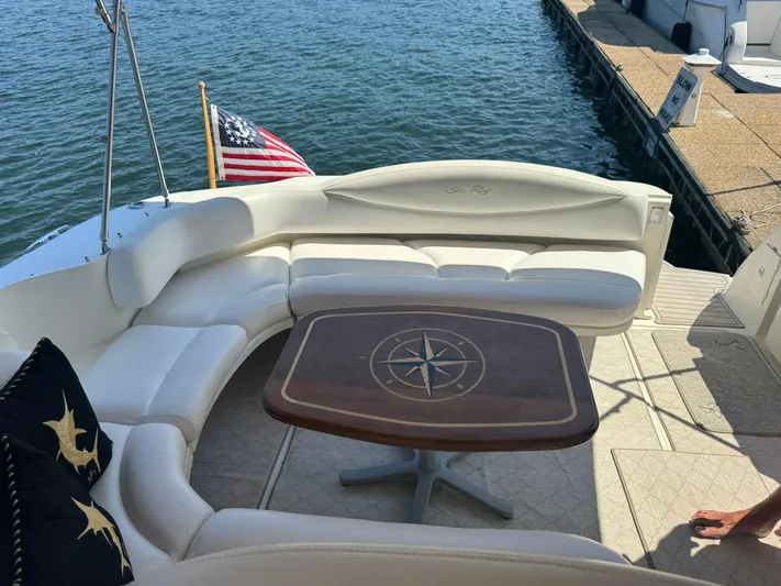  Yacht Photos Pics 2001 Sea Ray 380 Sundancer yacht with elegant seating and nautical-themed table, docked by the water.