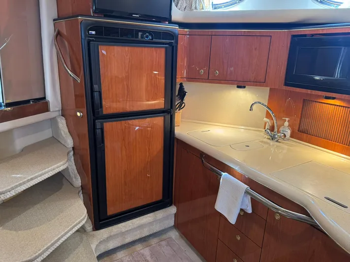  Yacht Photos Pics 2001 Sea Ray 380 Sundancer interior kitchen with wood cabinets, fridge, and sink.