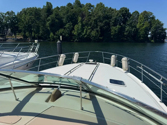  Yacht Photos Pics 2001 Sea Ray 380 Sundancer yacht on calm water near lush green shoreline.