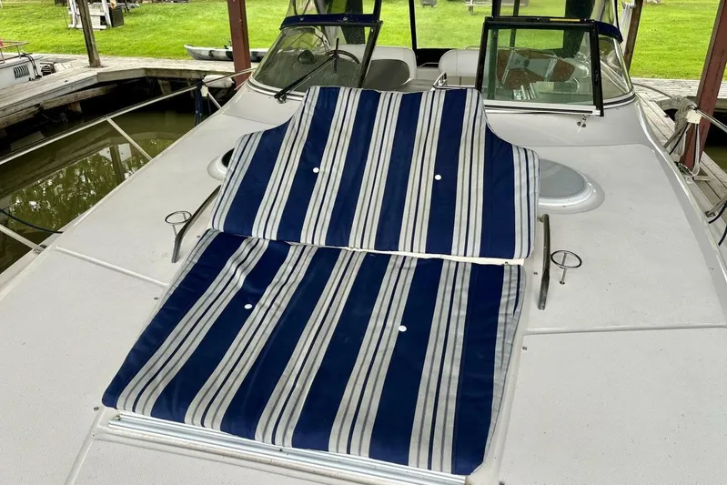  Yacht Photos Pics 2008 Regal Commodore 3760 IO boat with striped deck cushions, docked near grassy area.