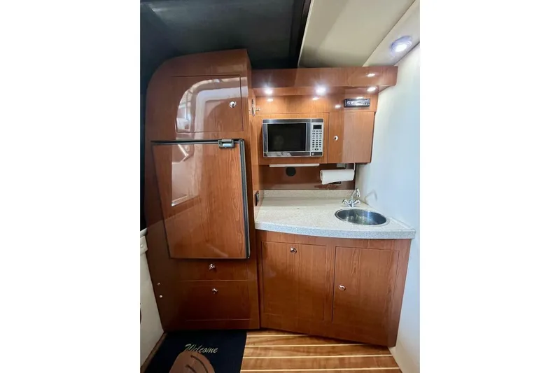  Yacht Photos Pics 2008 Regal Commodore 3760 IO boat kitchen with wood cabinetry, sink, and microwave.