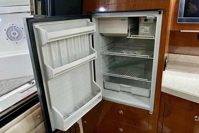  Yacht Photos Pics Open refrigerator inside 2008 Regal Commodore 3760 IO yacht, showcasing interior shelves and storage.