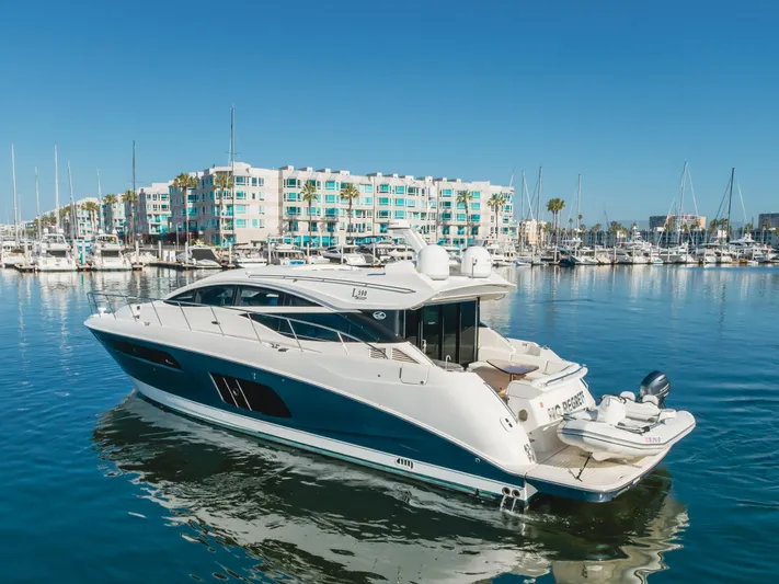 No Regrets Yacht Photos Pics 2016 Sea Ray L590 yacht docked in a marina with colorful buildings in the background.
