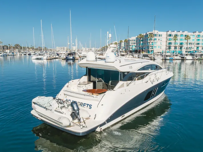No Regrets Yacht Photos Pics 2016 Sea Ray L590 yacht docked in a marina with clear blue water.