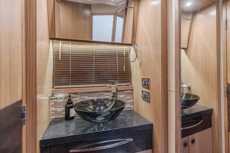 No Regrets Yacht Photos Pics Luxurious bathroom interior of 2016 Sea Ray L590 yacht with modern glass sink and wooden accents.