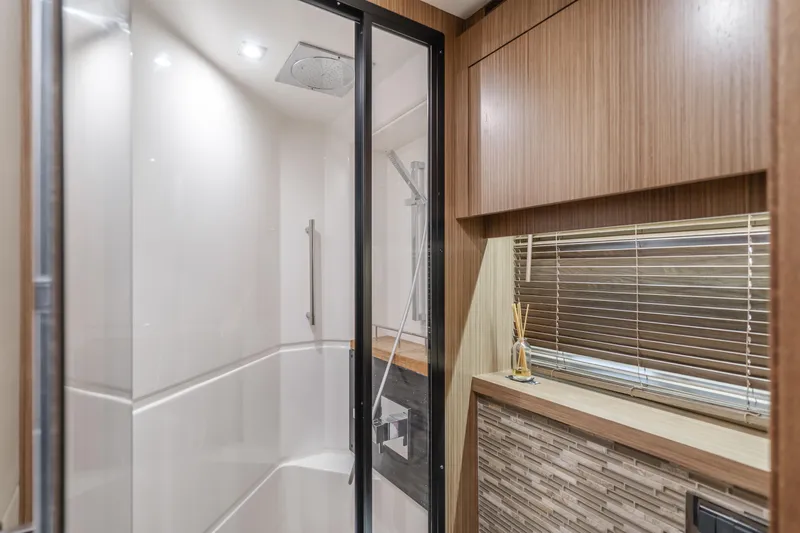 No Regrets Yacht Photos Pics Luxurious bathroom interior of 2016 Sea Ray L590 yacht with modern shower and wood accents.