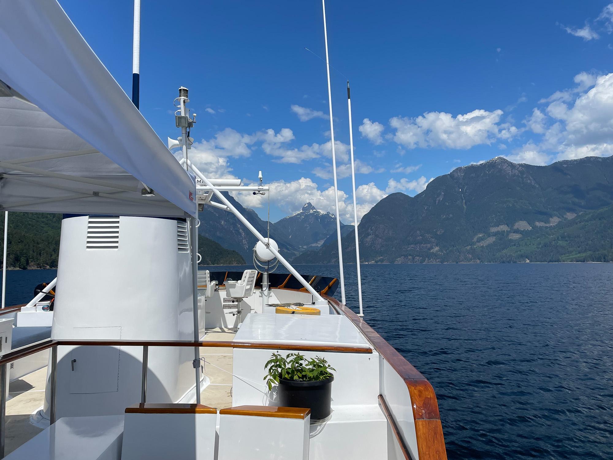 Custom 1967 George Moore Passagemaker yacht cruising on a scenic lake with mountain views.