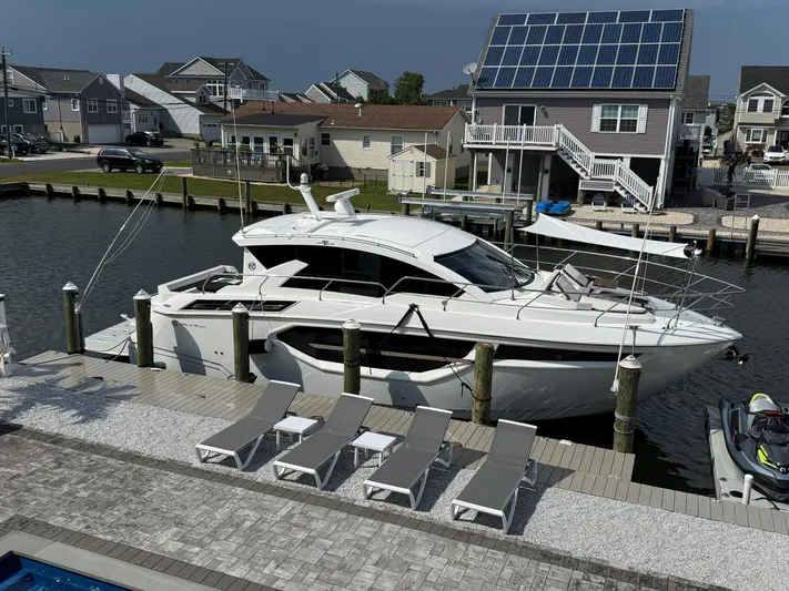  Yacht Photos Pics 2018 Cruisers Yachts 42 Cantius docked near waterfront homes with solar panels.