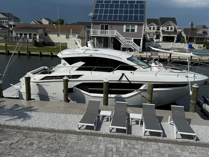  Yacht Photos Pics 2018 Cruisers Yachts 42 Cantius docked near waterfront homes with solar panels.