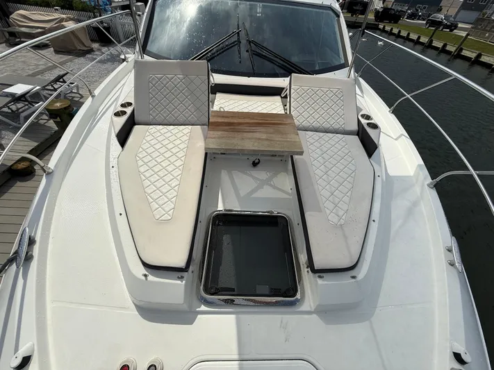  Yacht Photos Pics 2018 Cruisers Yachts 42 Cantius bow with cushioned seating and wooden table.